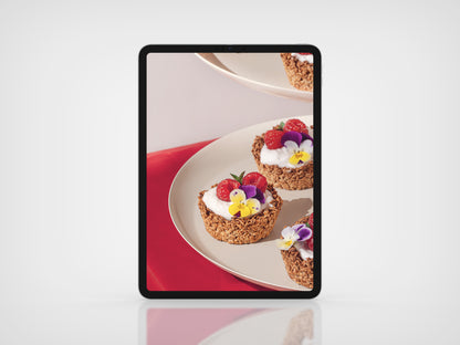 Two dessert cups with berries and cream on a plate, displayed on a tablet screen. This is Bontà Magazine