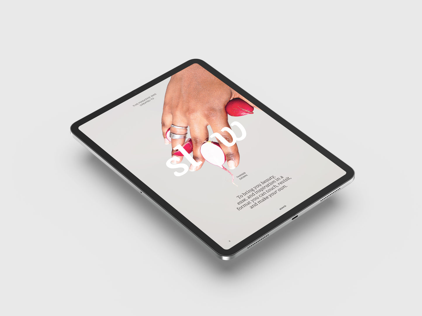 Vegan Food Magazine Digital page.
Hand holding a small white object over an open book on a tablet screen.